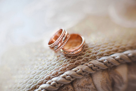 Elegant gold wedding rings on the sofa.