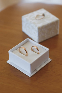 Elegant gold engagement rings in wooden box.