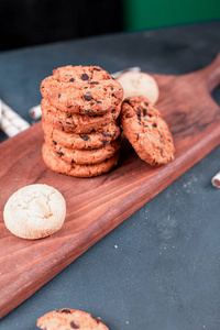 Oatmeal cookies and biscuits on a wooden cutting board on a blue