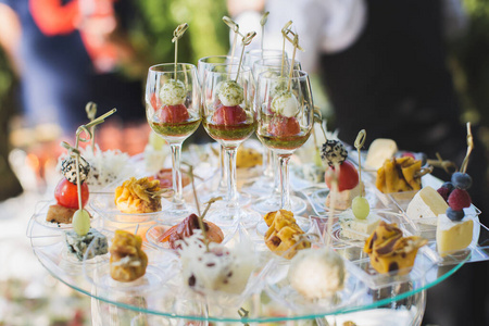婚礼招待会。小吃和酒杯放在玻璃桌上。