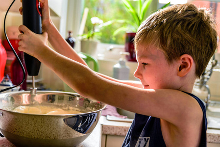 小男孩在厨房用搅拌机做煎饼
