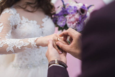新郎把戒指戴在新娘的手指上。