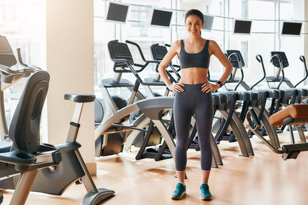 瘦弱女人准备好锻炼了一个穿着运动服的瘦弱的女人,站在健身房的时候