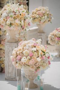婚礼拱门背景上花瓶里的一束美丽的玫瑰花。婚礼布置得很漂亮。