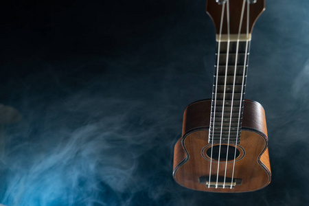 夏威夷四弦琴吉他孤立在黑色背景与烟雾