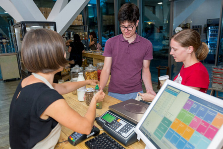 女店员在办公桌旁为一对夫妇服务.照片