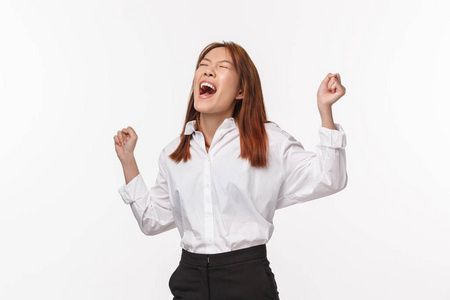 兴高采烈,如释重负的亚洲年轻女子庆祝胜利,举手欢呼,喜获成功,中了
