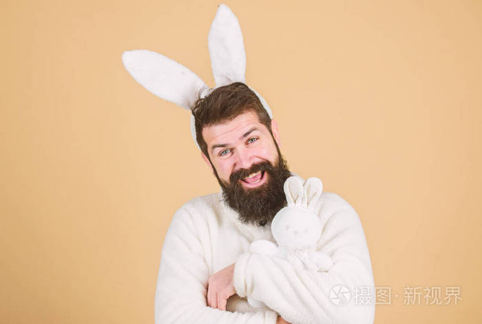 复活节兔是复活节和春天的象征.快乐的嬉皮士,长着兔子耳朵,抱着兔子