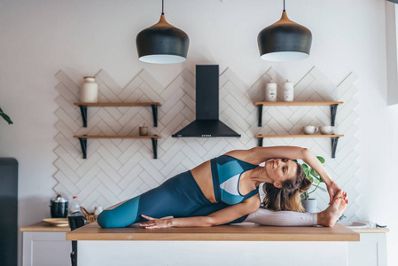 妇女在家里伸展身体做坐姿侧弯.照片