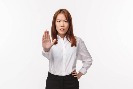 请住手，不要擅闯。表情严肃气愤的亚洲女性试图阻止规则生效，在禁止不同意的手势中拉手，给予警告，白色背景