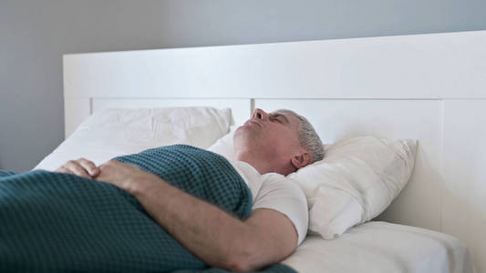 睡在床上的疲惫的中年男子图片
