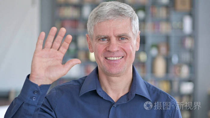 中年男子在办公室对着镜头挥手的画像
