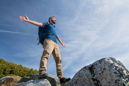 成熟的男人在夏天背着背包在山上徒步旅行，冥想。