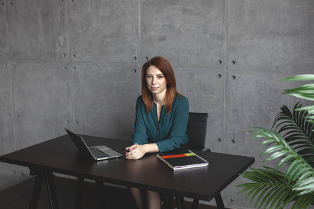 Young caucasian women work on laptop. In green blouse. 