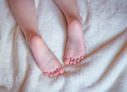 婴儿的脚放在毯子上