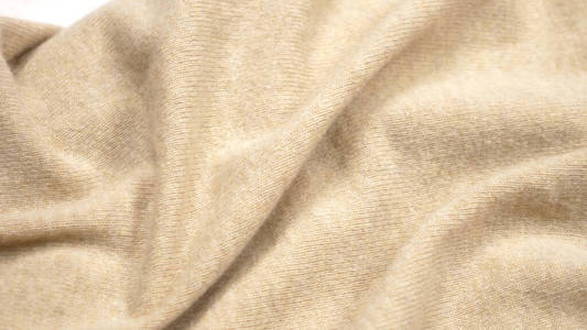 背景织物纹理。米色羊绒织物的褶皱。特写