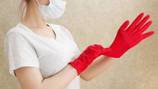 妇女戴上医用手套，预防冠状病毒。检疫