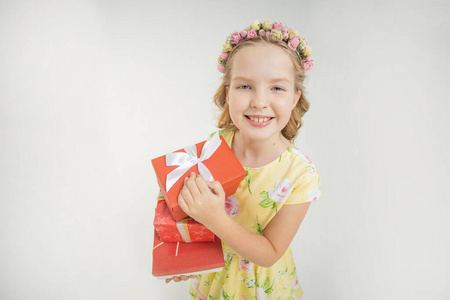 快乐女孩的肖像，有几个礼品盒，头上戴着漂亮的花环，节日概念