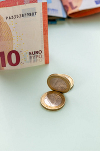 一捆浅色背景的欧元纸币和硬币