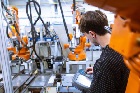 工程师在智能工厂，汽车工业，工业概念中建立自动机械手臂