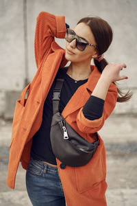 Elegant woman in a brown coat in a spring city