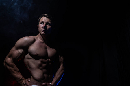 Muscular man showing muscles isolated on the black background. C