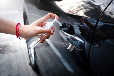 一名妇女在触摸前用消毒剂将手放在车把手上
