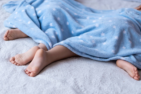 孩子们脚在床上.休息的孩子们把注意力集中在赤脚上.