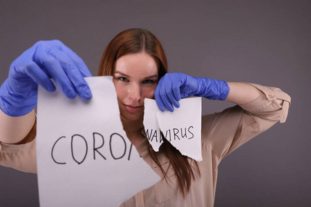 Woman holding pieces of paper with sign coronavirus