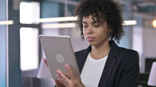 严肃的非洲女商人在平板电脑上工作的肖像