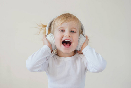 家，科技和音乐概念戴着耳机听音乐和唱歌的小女孩
