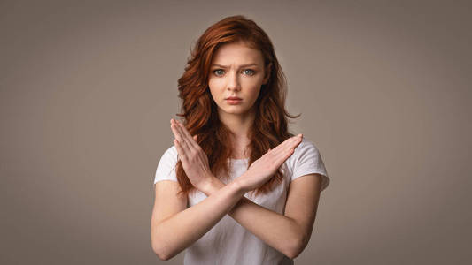 女孩禁止手势女孩在灰色背景上做手势不交叉的手,全景照片