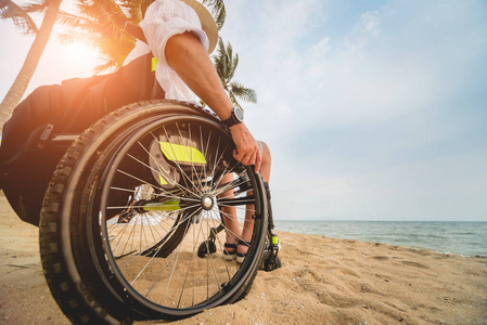 沙滩上坐轮椅的残疾人。