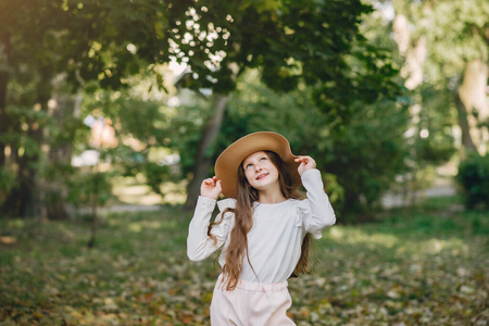 公园里戴着棕色帽子站在公园里的小女孩