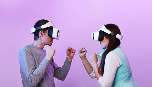 一对戴着虚拟现实耳机的夫妇正在玩游戏和打架。