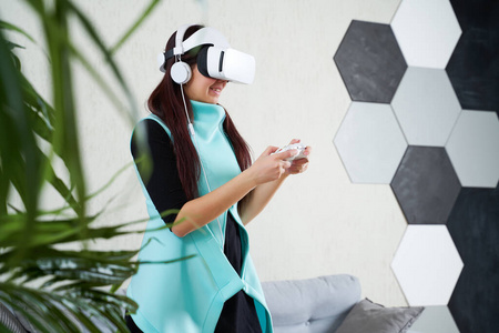 戴着虚拟现实耳机和游戏板的女人正在玩游戏。