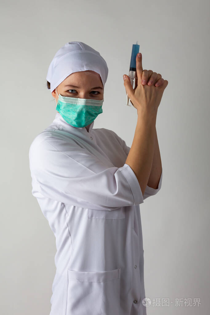 穿医用外套的女孩拿着一个大注射器注射器里装着蓝色液体就像一把枪