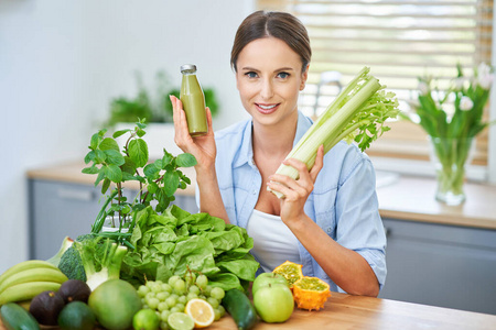 厨房里有绿色食品的健康成年妇女