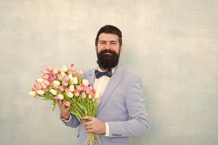 留着胡子的男人戴着郁金香花的领结.新郎新娘在婚礼上.春天的花束.