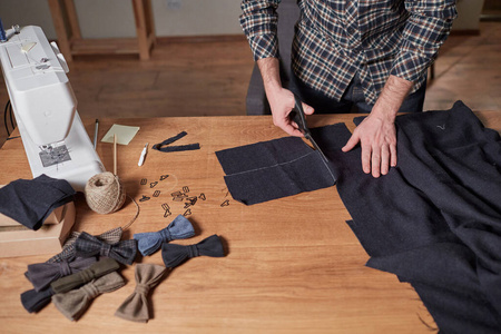 特写裁剪羊毛织物。线条图案。工匠用毛料做蝴蝶结的长方形毛坯。在纺织工作室用缝纫机工作。