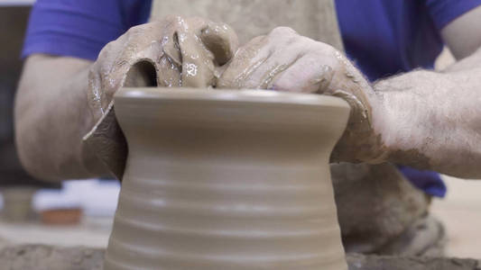 特写专业陶工创造陶罐粘土。库存镜头。陶工在车间制罐过程中的精湛技艺