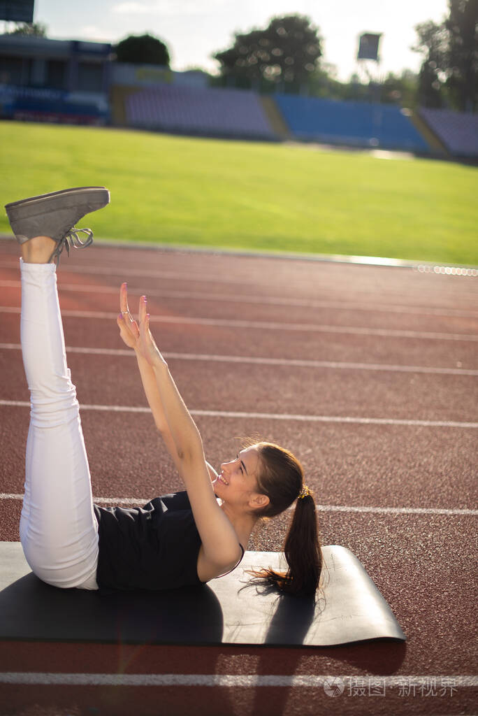 女运动员在阳光明媚的日子户外做柔韧性练习