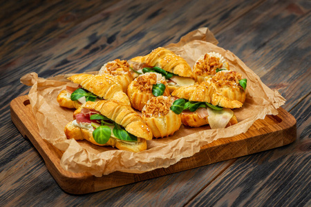 Croissants with ham and greens. Profitroli with cream filling 