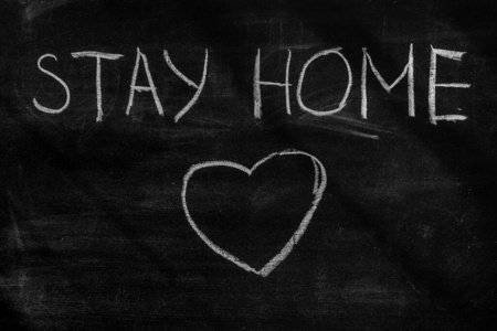 冠状病毒大流行行为规则或健康建议呆在家里。呆在家里。呆在家里的黑板上写着。