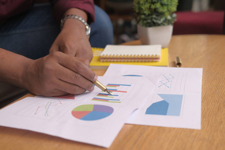 man hand analyzing financial chart on  desk 