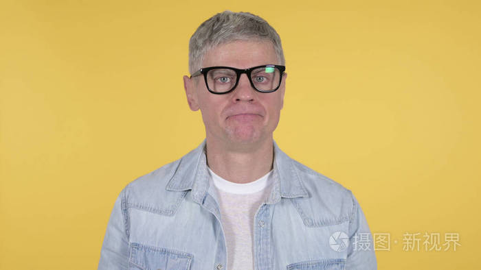 漫不经心的老人在黄色背景上摇头否认