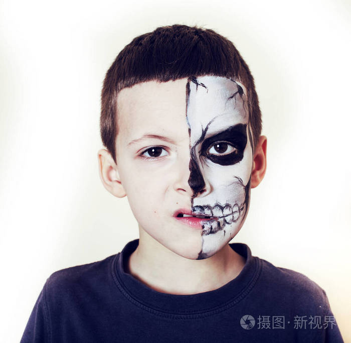 可爱的小男孩用脸漆似的骷髅来庆祝万圣节人们的生活方式理念孩子们在