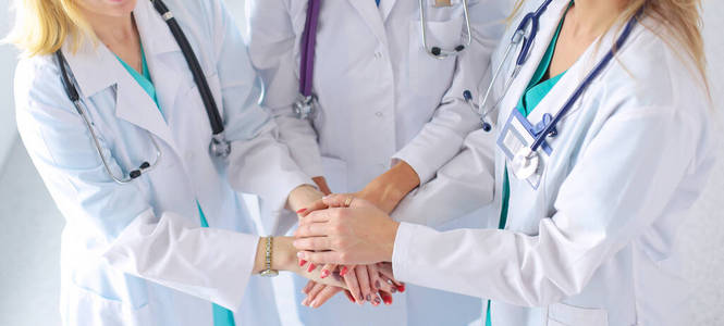 医疗队里的医生和护士们在互相叠手。