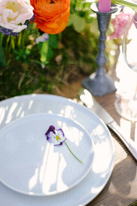 在豪华婚礼上摆桌子，桌上摆着漂亮的花。