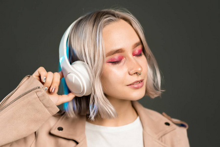 Mysterious hipster teenager listening to music with headphones. 